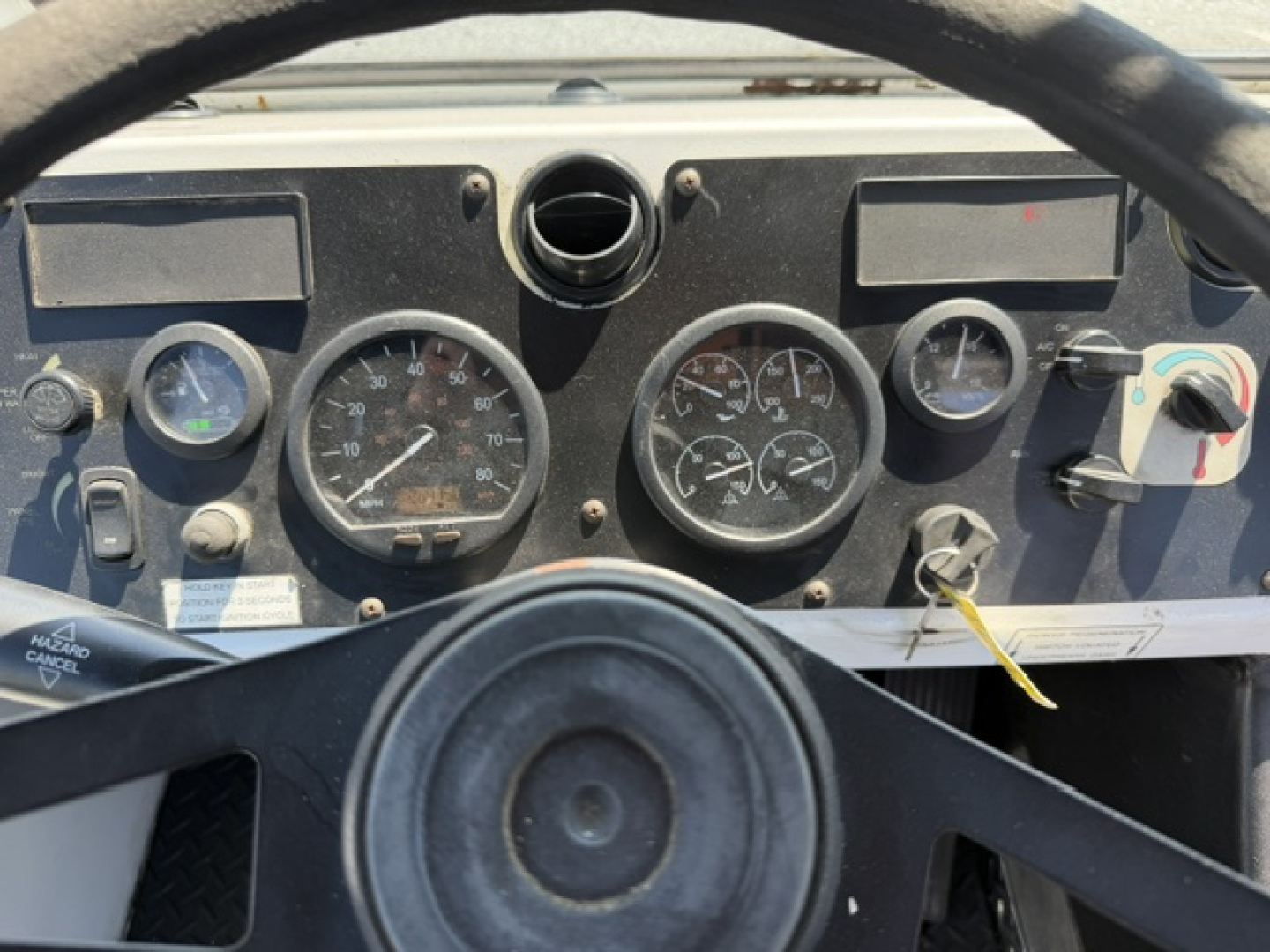 Dashboard of a capacity Sabre DOT truck showing analog gauges and steering wheel in view.
