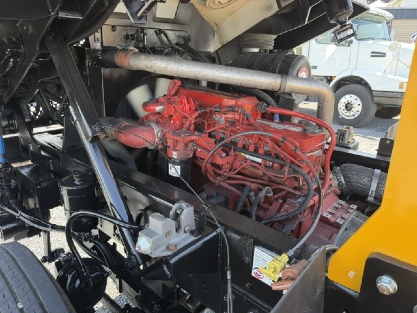 Engine bay of Capacity Sabre truck showing red diesel engine with hoses and surrounding components.