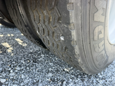 Tire close-up on a vehicle wheel with visible tread pattern and sidewall, part of a yard trucks listing.