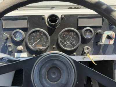 Dashboard of a capacity Sabre DOT truck showing analog gauges and steering wheel in view.