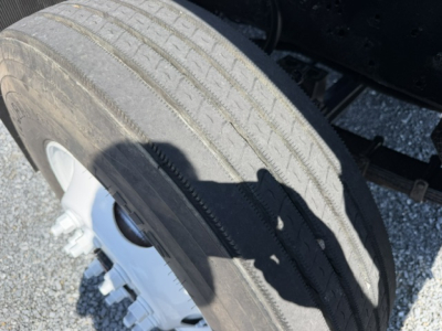 Wheel and tire view of a used Capacity Sabre DOT truck showing a large treaded tire and steel wheel, part of the rear axle assembly.