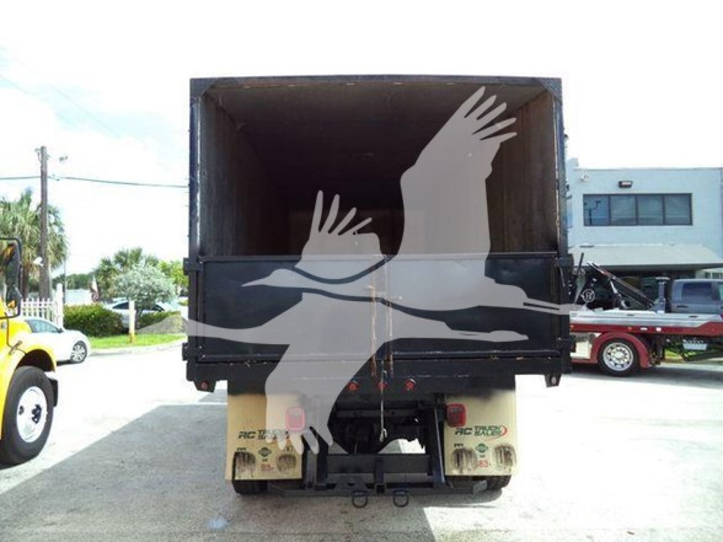 Truck dump bed with open top showing chassis and rear wheels, Isuzu FTR listing, chipper category, stock number T00444.