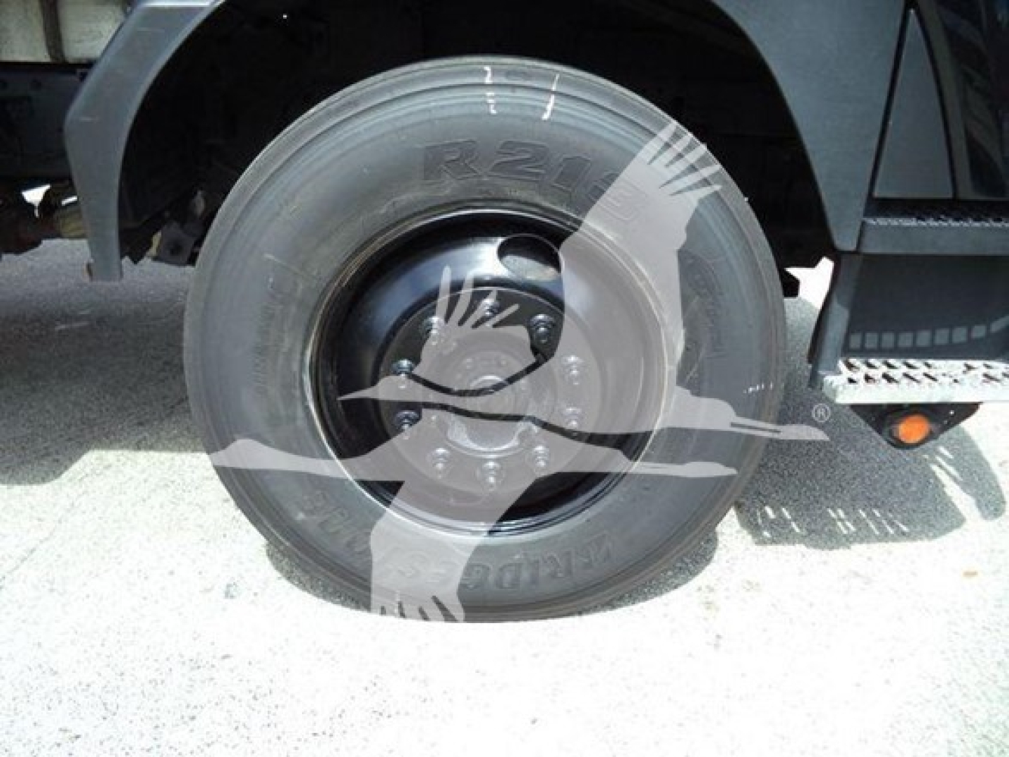 Front wheel and tire area of a 2020 Isuzu FTR truck showing tire sidewall with R2? marking and hub with bolt pattern.