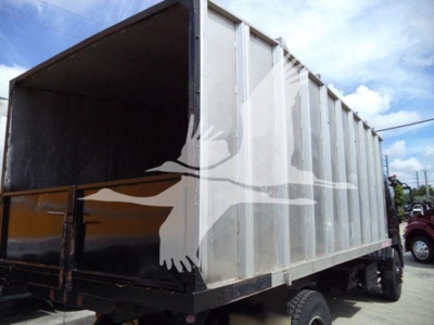 Isuzu FTR dump truck side view showing metal cargo bed and wheel alignment.
