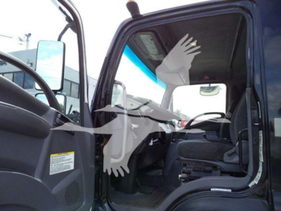 Isuzu FTR truck interior view with open cab door showing steering wheel and dashboard, VIN plate area not visible, stock tag, used vehicle.