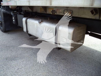 Isuzu FTR undercarriage showing large rectangular fuel tank mounted under cab with fuel lines and support straps.