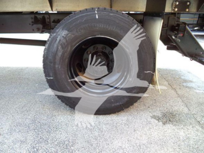 Isuzu FTR truck wheel and tire view under chassis showing spare hub and framing.