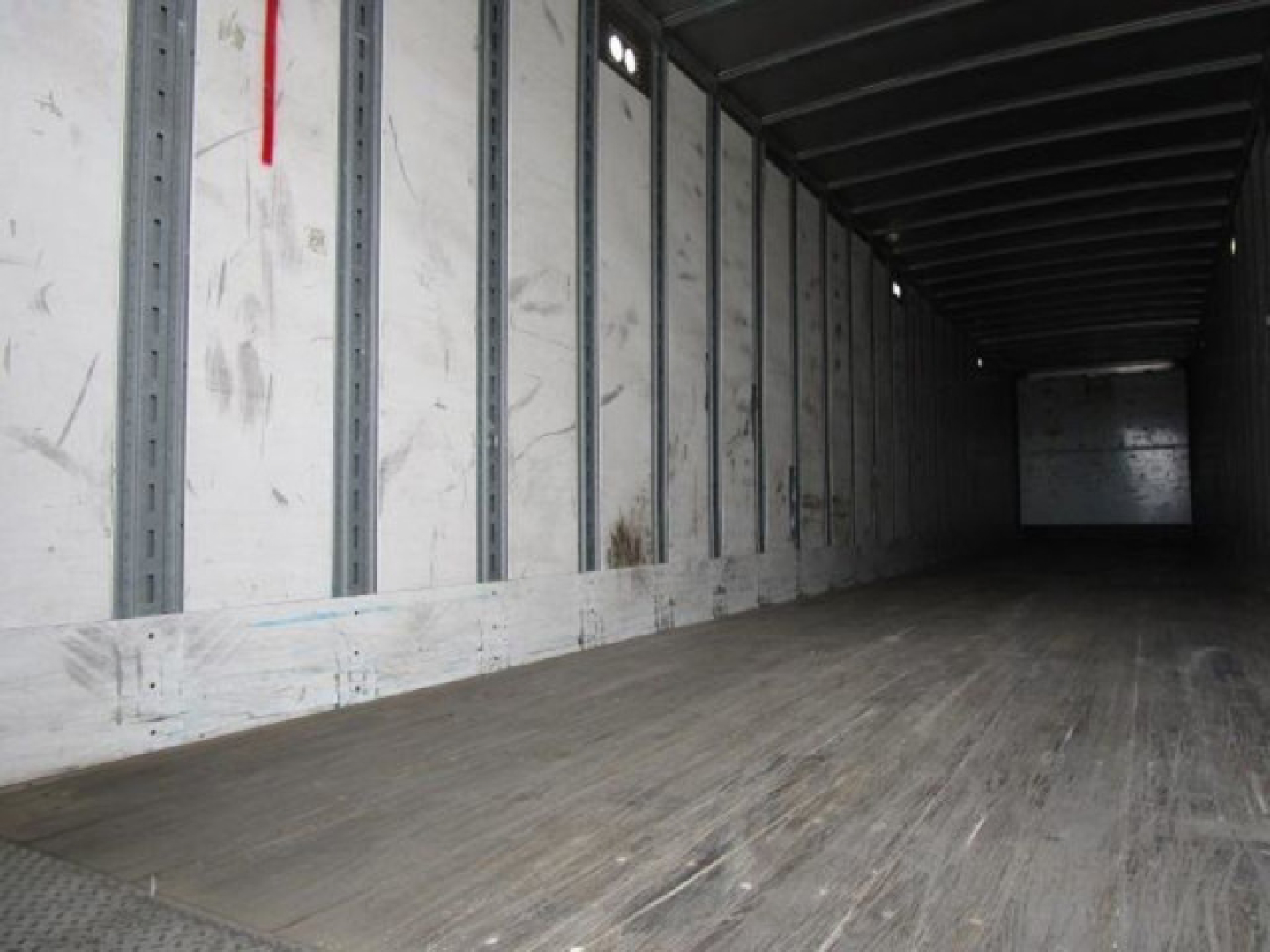 Interior of a 2014 Stoughton van trailer showing wooden floor and metal side rails, empty cargo area.