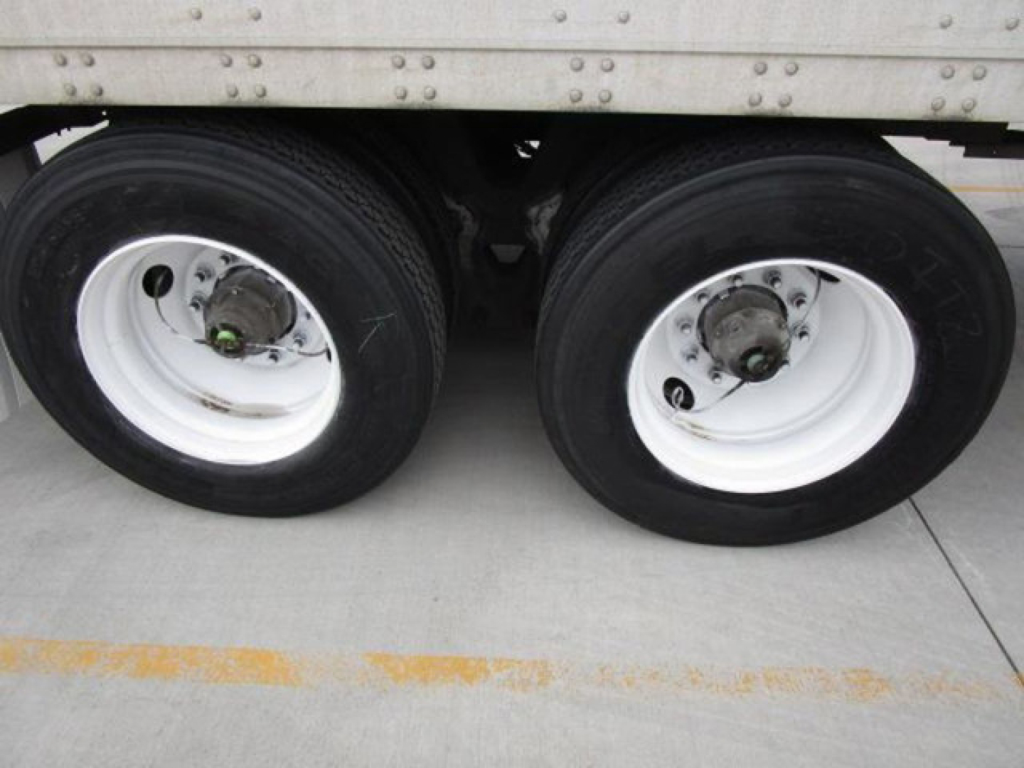 Trailer axle wheels on a 2014 Stoughton Van showing dual rear tires and white rims under the trailer