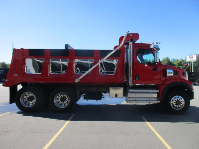 Western Star 47X dump truck side view showing red dump bed with black side rails and chrome steps; cab and chassis; wheel rims; visible white and black text unlikely legible