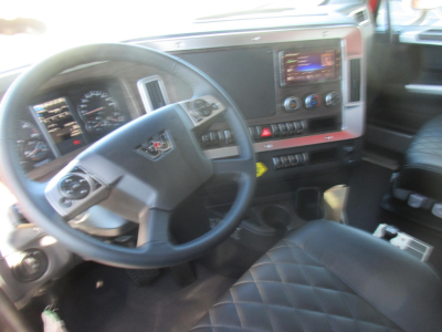 Interior of a new Western Star 47X truck showing steering wheel, dashboard with gauges, infotainment screen, and center console.