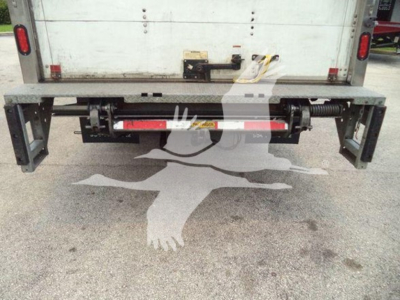 Isuzu NPR-HD rear view showing bumper-mounted underride guard and metal frame with painted red crossbar bar and mounting hardware.