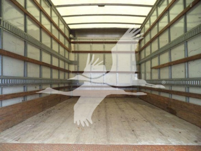 Truck cargo box interior showing wooden floor and metal sidewalls with tie-down rails.