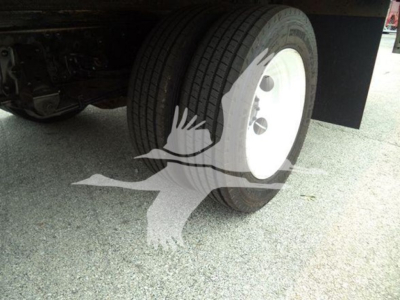 Isuzu NPR HD truck wheel and tire in view under chassis, white steel wheel, dual rear tires visible.