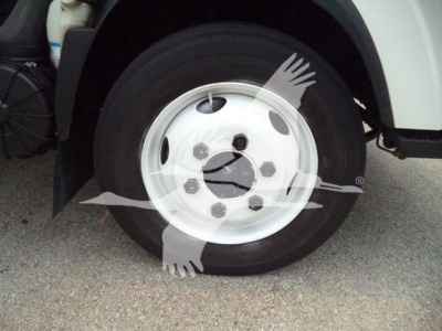 Isuzu NPR HD wheel and front fender showing steel rim with hubcap, black tire, and surrounding wheel well.