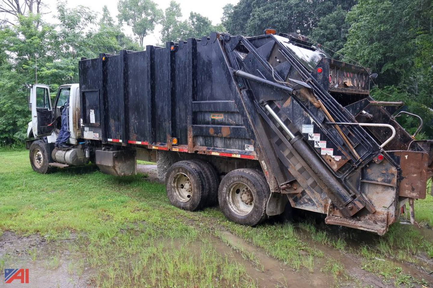 Truck rear and side view showing a 2014 International WorkStar 7600 Pak-Mor 30 yard packer body in a used condition.