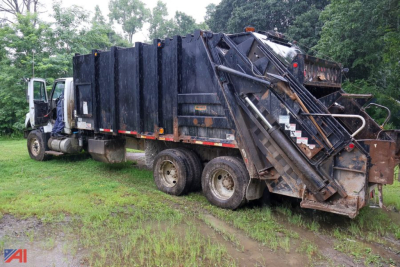 Truck rear and side view showing a 2014 International WorkStar 7600 Pak-Mor 30 yard packer body in a used condition.