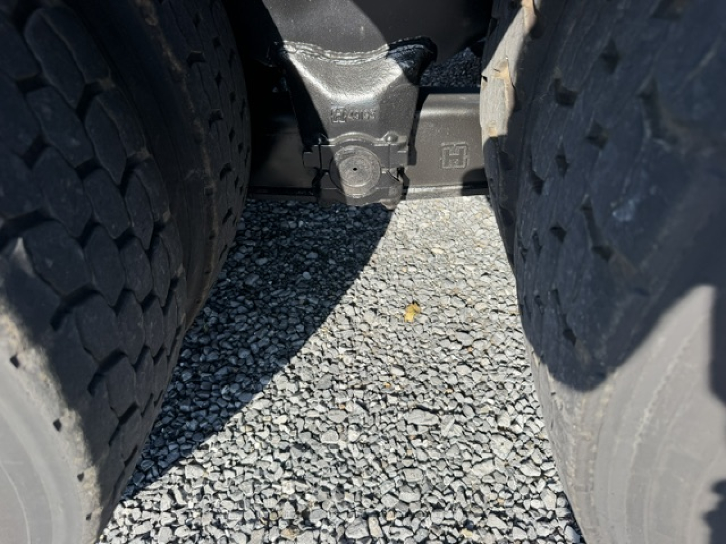 Vehicle undercarriage showing dual tires and hitch area with factory stamping.