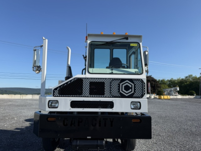 Truck front view showing capacity plate, DOT, TJ6500 label, and grille with logo; wide bumper and cab with side mirrors.