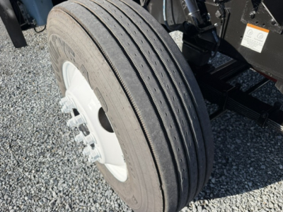 Wheel and tire assembly of a TJ6500 capacity truck showing dual rear tires and part of the chassis.