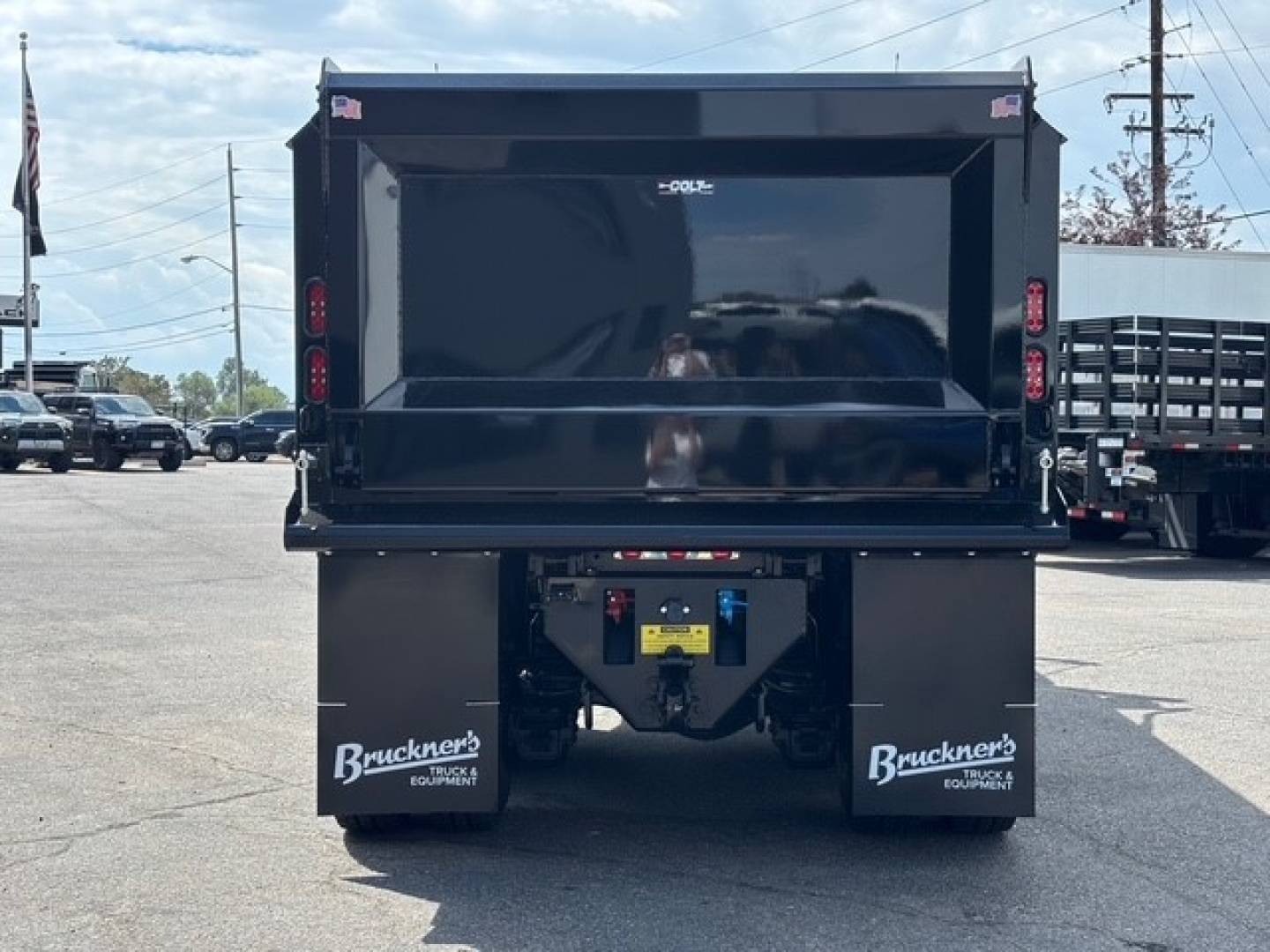 Dump truck rear showing black dump bed with bumper, taillights on sides, and mud flaps labeled Bruckner's Equipment.
