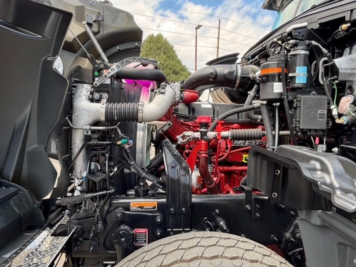 Mack GR64F engine bay showing diesel engine and various hoses and components