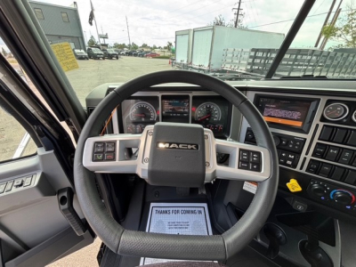 Dashboard and steering wheel of a 2026 Mack GR64F dump truck cab, showing Mack emblem on steering wheel and instrument cluster."