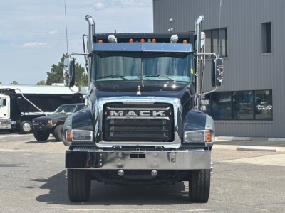 Mack GR64F dump truck front view showing chrome grille with MACK letters, large bumper, headlights, and roof-mounted lights.