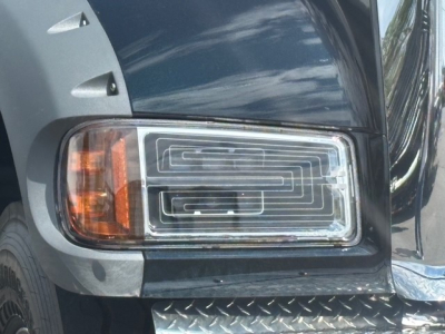 Grille/side headlight area of a 2026 Mack GR64F dump truck showing headlight assembly and bumper.
