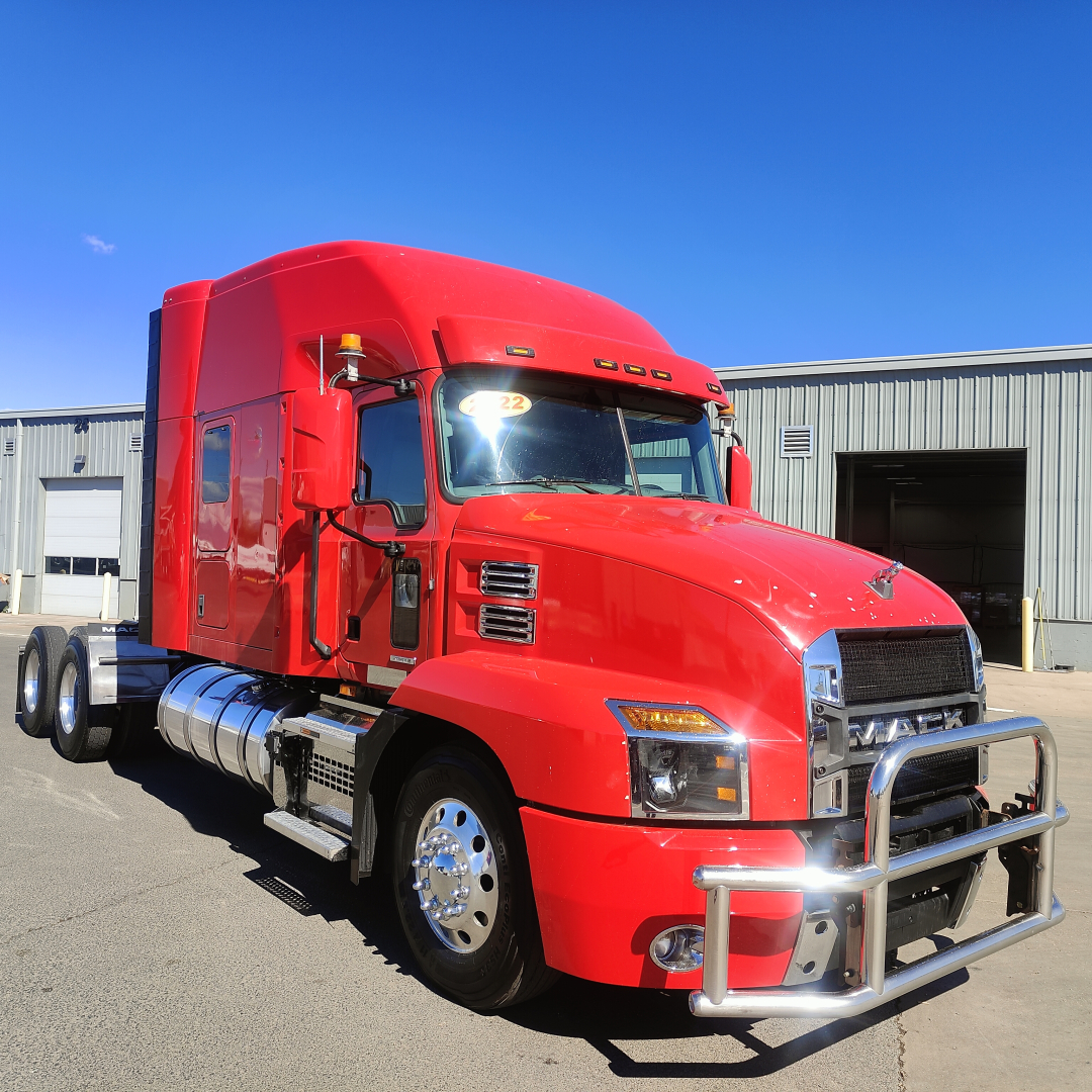 Mack AN64T70 heavy duty truck in red color with chrome bumper and sleeper cab, front three-quarter view.