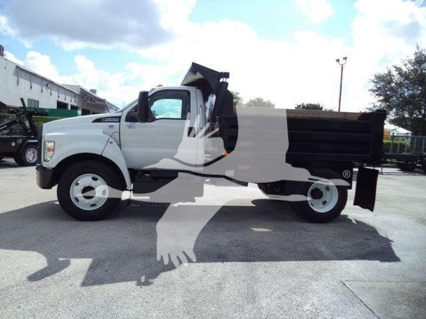 Side view of a white 2017 Ford F-650 XL SD dumping truck with a black dump bed, cab tilt area, and large front wheel; stock/ID not visible.