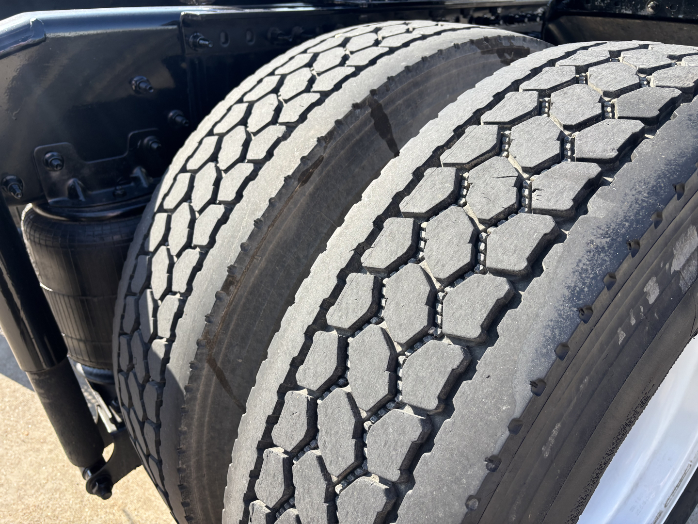 Two rear truck tires with deep treads mounted on a Mack AN42T tractor showing dual tires and wheel rims.