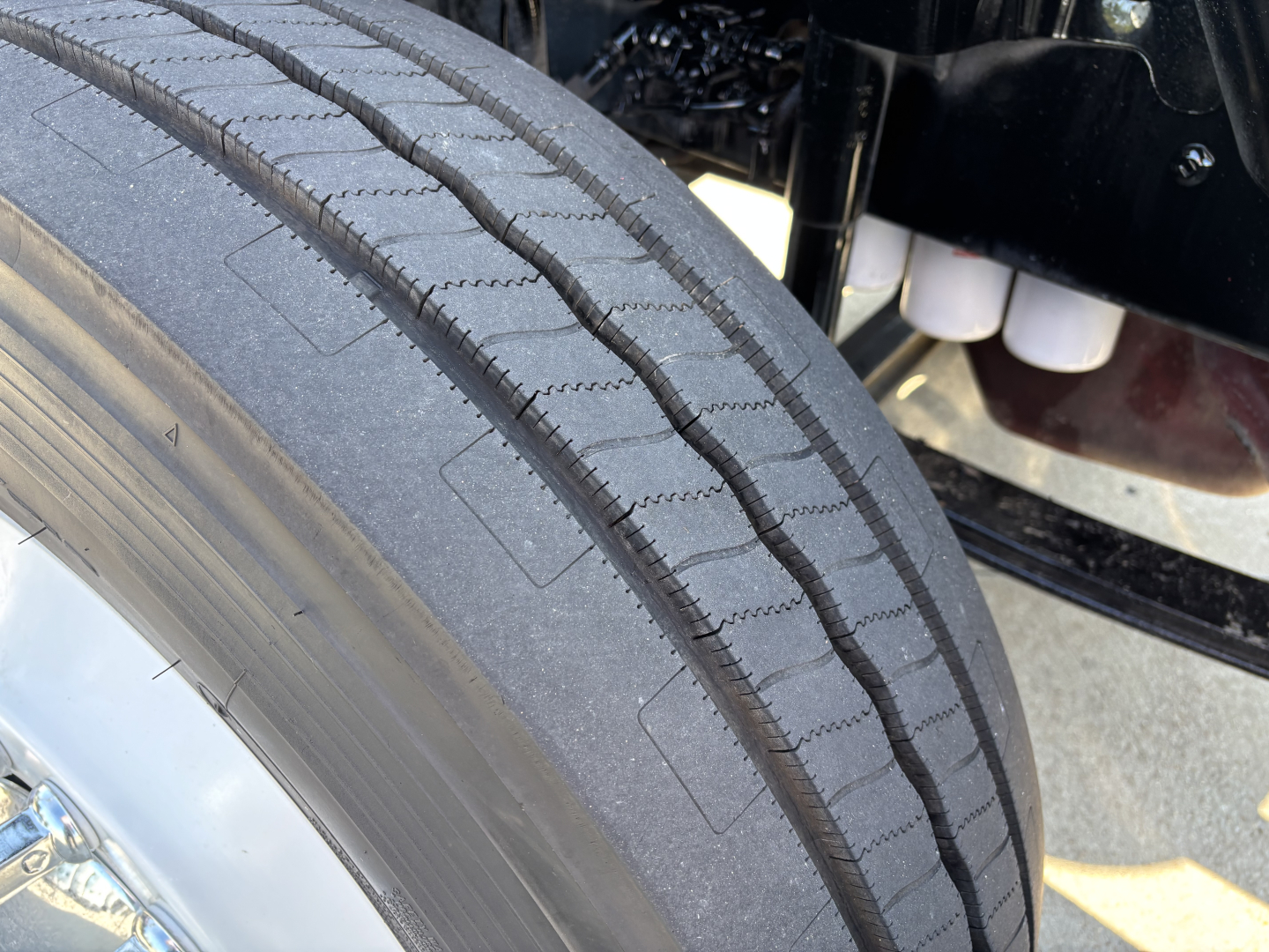Tire tread close-up on Mack AN42T truck showing front wheel, dual tread pattern and suspension components.