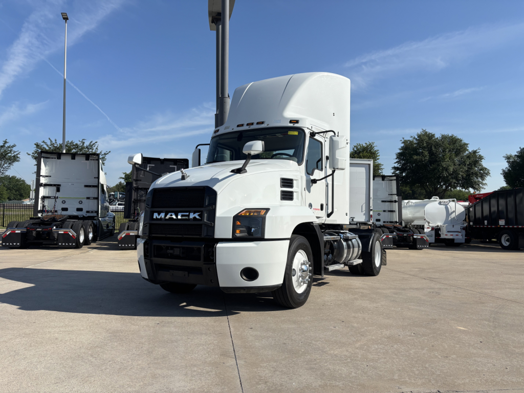 Mack AN42T conventional daycab tractor in white, front-left view, with streamlined hood and large Mack grille, parked in a lot.