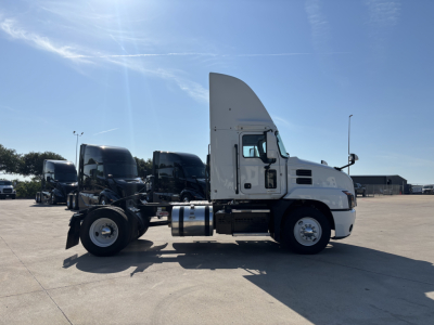 Truck side profile showing 2022 Mack AN42T conventional daycab with white cab, black chassis, and fuel tanks.