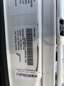 Truck door jamb label showing Mack Trucks Inc; VIN 1M1AN2AY7NM002754; stock B3251P; GA-ZFY-3D1-8KU2; barcode; MAC TRUCKS INC A P USA ATL; various alphanumeric IDs.