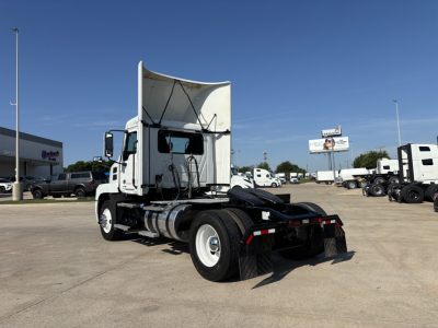 Mack AN42T tractor in a truck lot showing rear with fifth wheel and dual rear axles; white cab and chassis.
