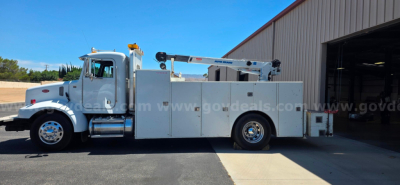 Peterbilt 330 service truck side view with utility boxes and crane in truck bed, white cab, clear label of service vehicle
