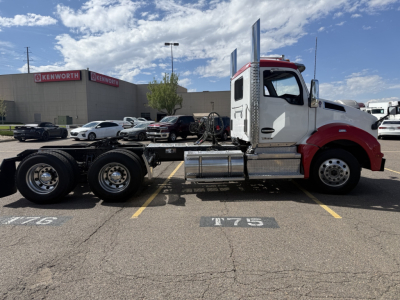 Kenworth T880 tractor in a parking lot side profile showing chassis and cab details with dual rear axles.