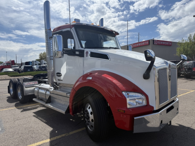 Truck cab and chassis of a white Kenworth T880 with red fenders, dual exhaust stacks, large chrome grille, and a chrome bumper.