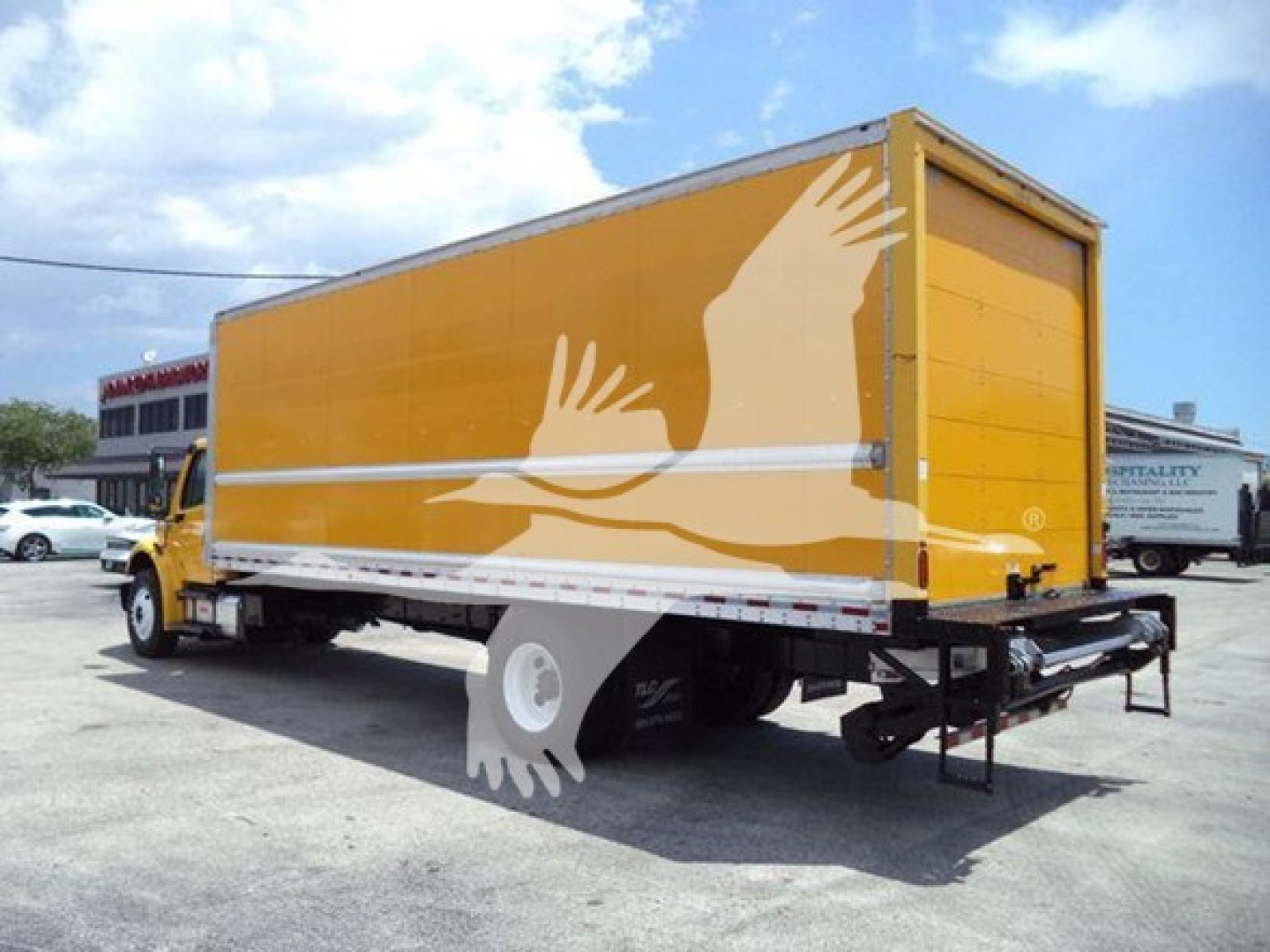Freightliner M2 106 box truck showing yellow cargo body with white illustrated hands graphic.