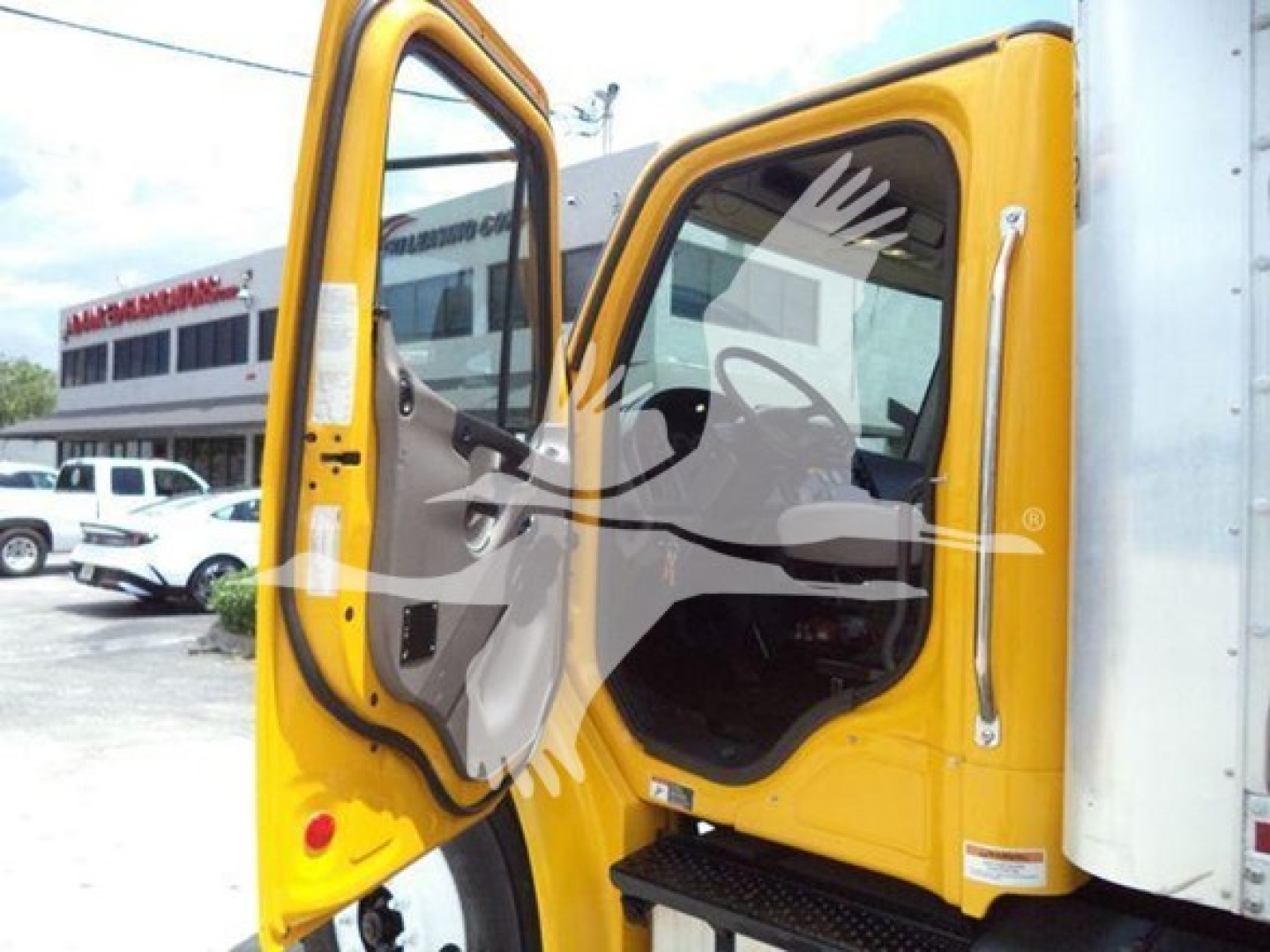 Cab doors open of a 2019 Freightliner M2 106 box truck showing the cabin interior and entry area.