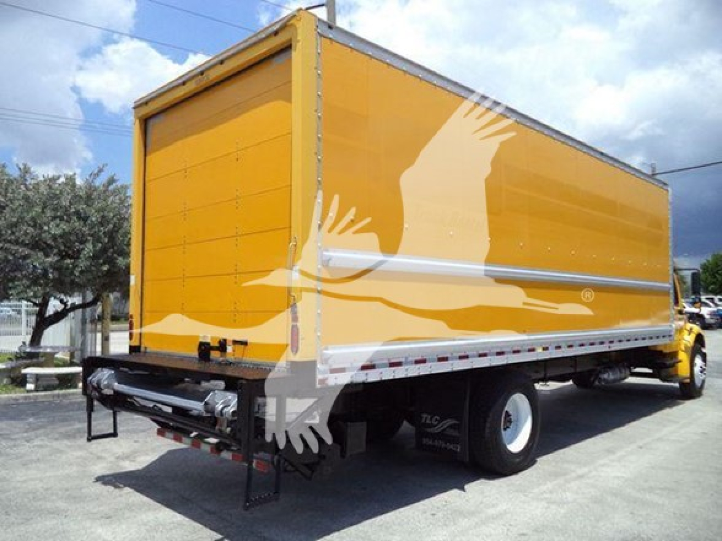 Freightliner M2 106 box truck rear and side view with yellow cargo box and graphic.