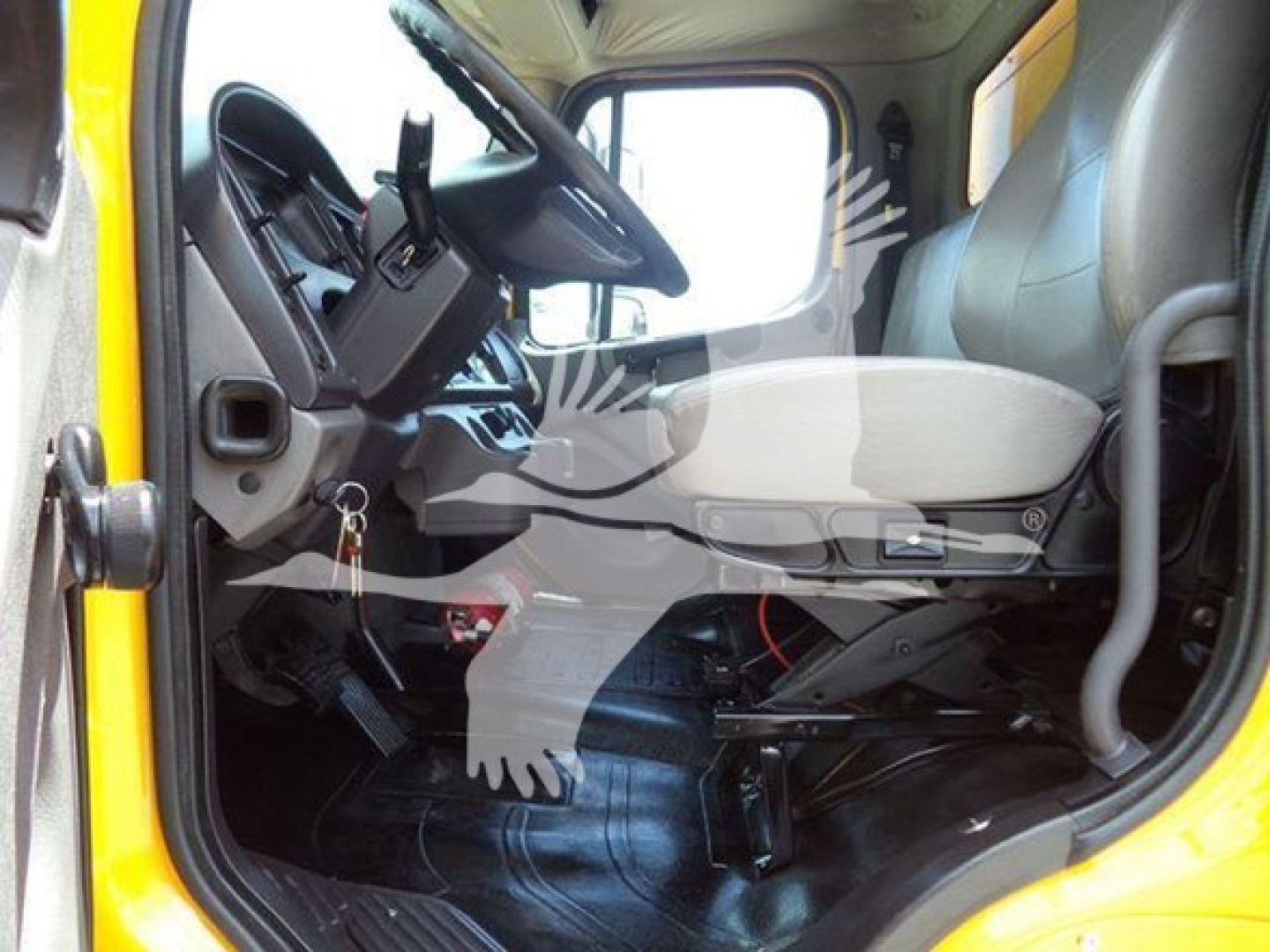 Cab interior of a 2019 Freightliner M2 106 truck showing the driver's seat and steering wheel from the open door.
