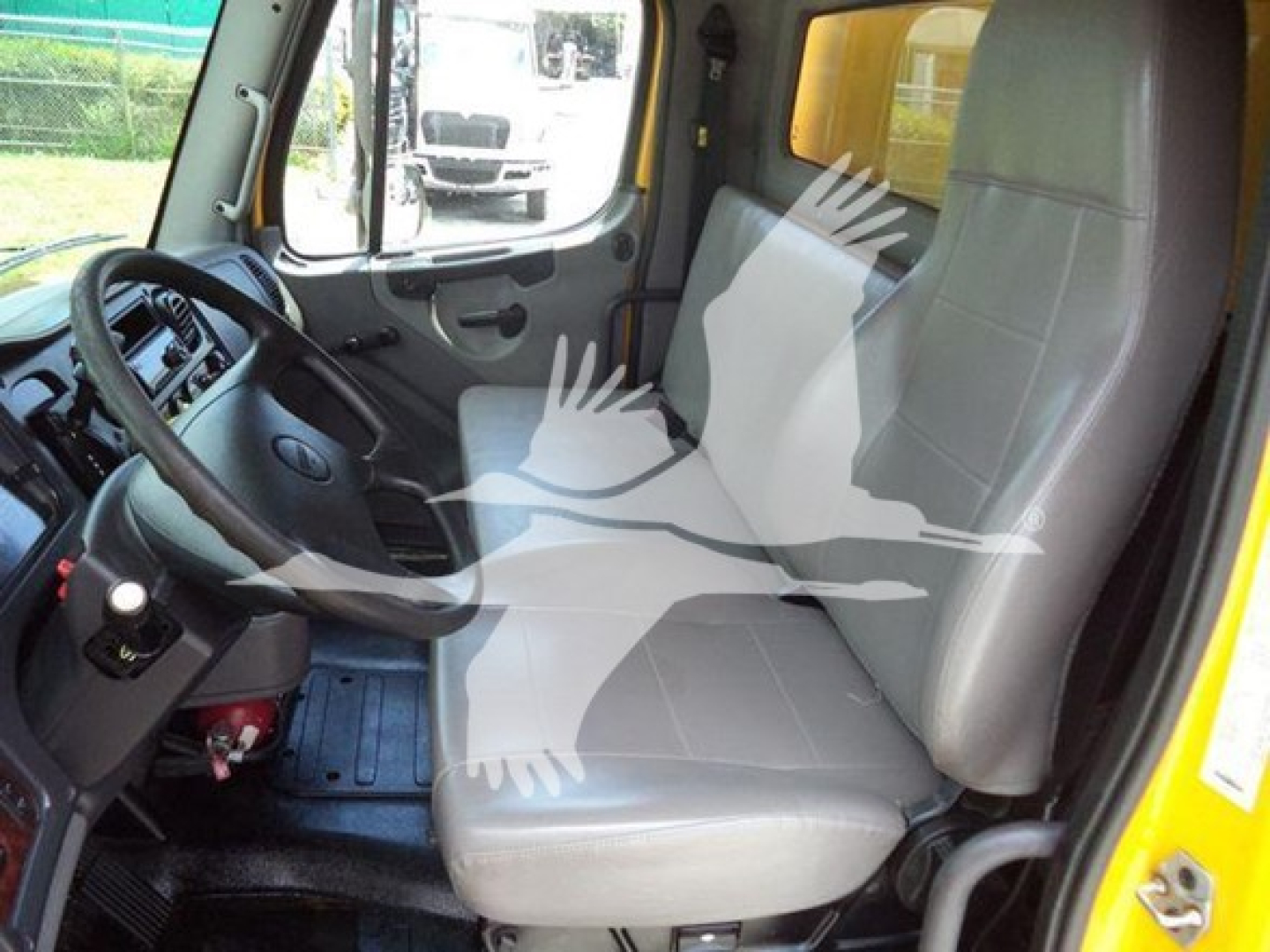 Truck cab interior of a 2019 Freightliner M2 106 showing driver's seat and passenger seat with steering wheel and dashboard visible.