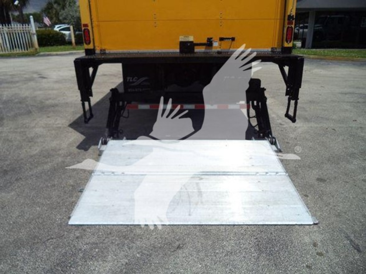 Rear view of a Freightliner M2 106 with a lowered aluminum ramp at the back, stock number TH6807, box truck in view.