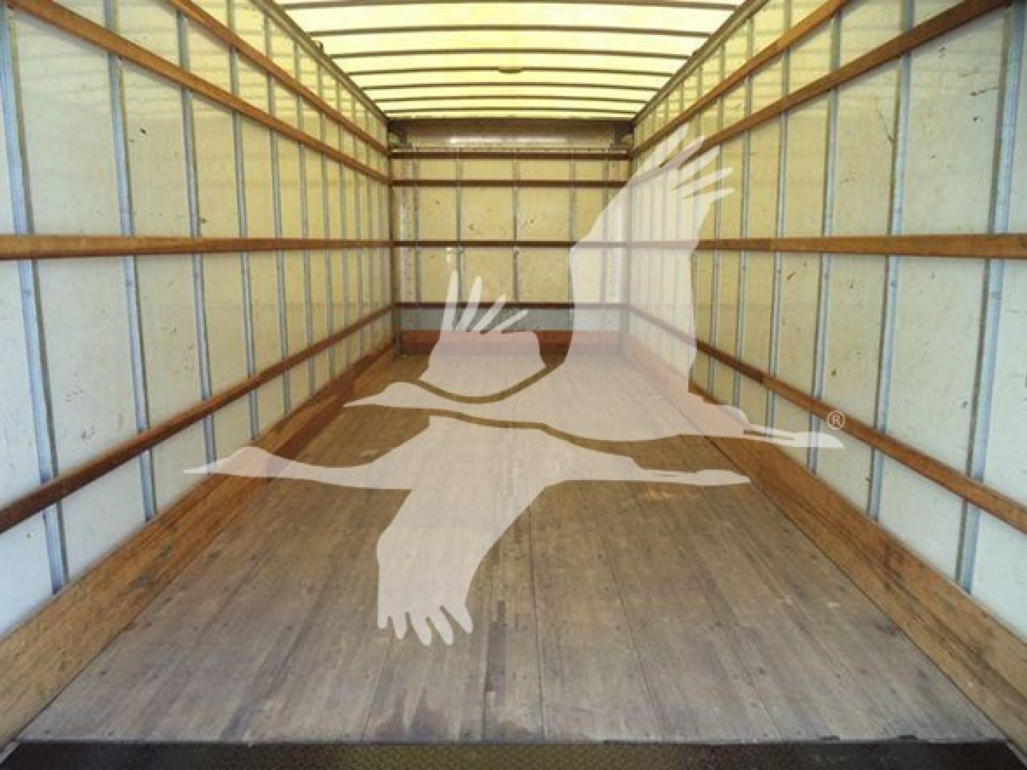 Freightliner M2 106 cargo truck interior with empty box area and wooden floor, long trailer walls, no visible cab components.