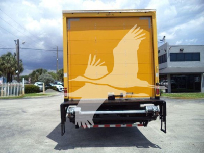 Truck rear view showing yellow freight box with white crane logo and rear underride guard.