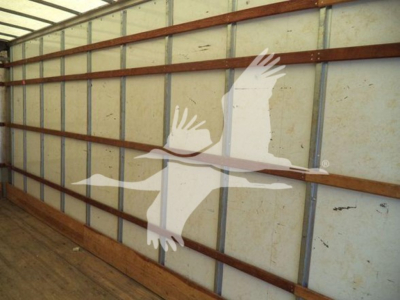 Freightliner M2 106 truck interior wall with large white logo of two birds in flight overlaying the wall. Side panels show wooden beams and metal framing.