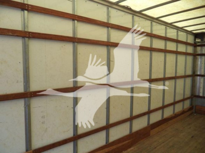 Truck trailer interior with metal wall framing and a graphic of a flying crane logo overlay.